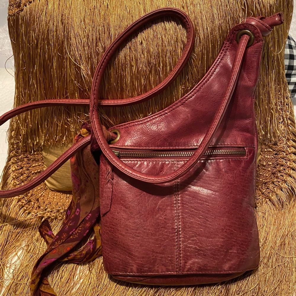 Oxblood colored soft leather crossbody handbag. diagonal cut for character